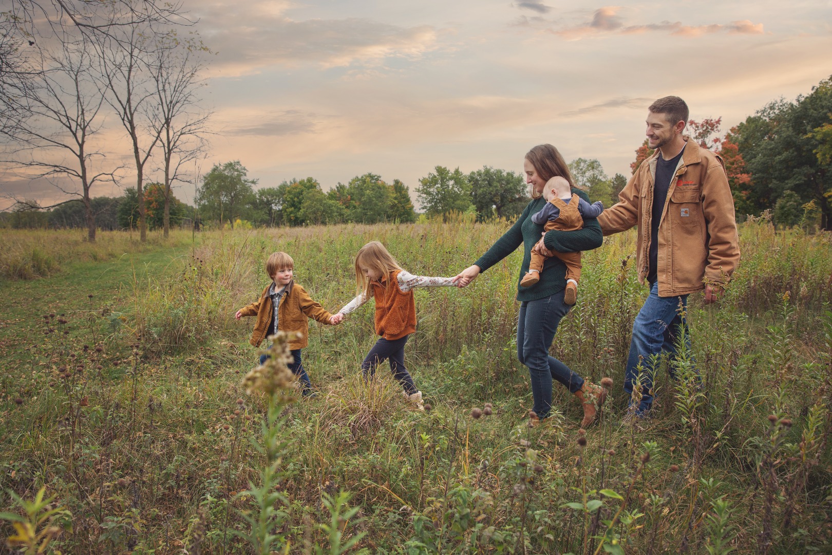 family walks together through a fall field