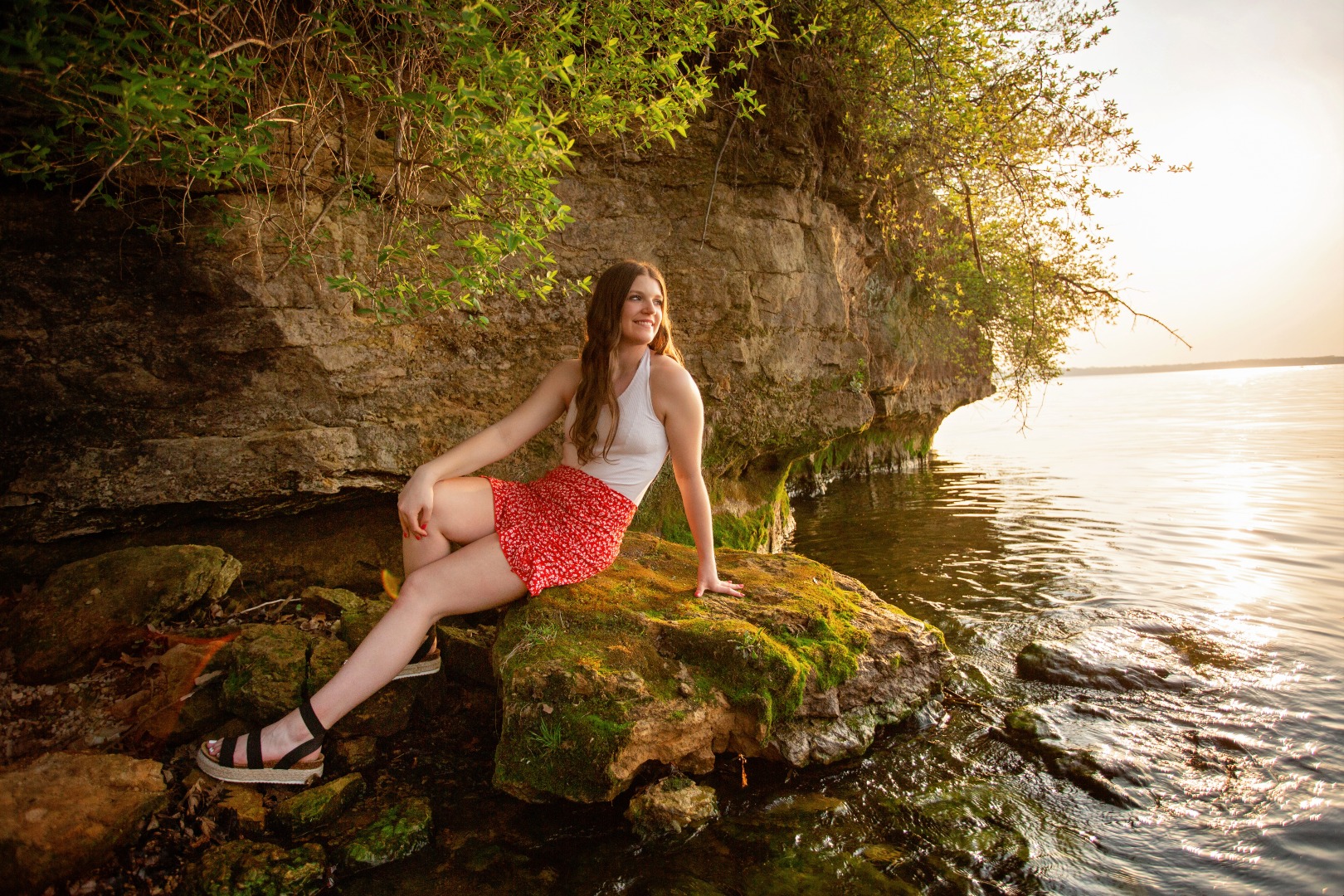 hs senior girl sits on a lake shore line