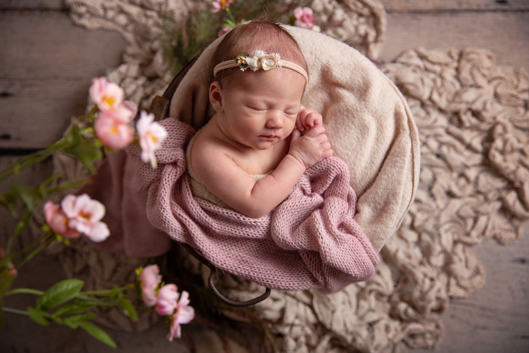sleeping newborn girl in pink with a headband