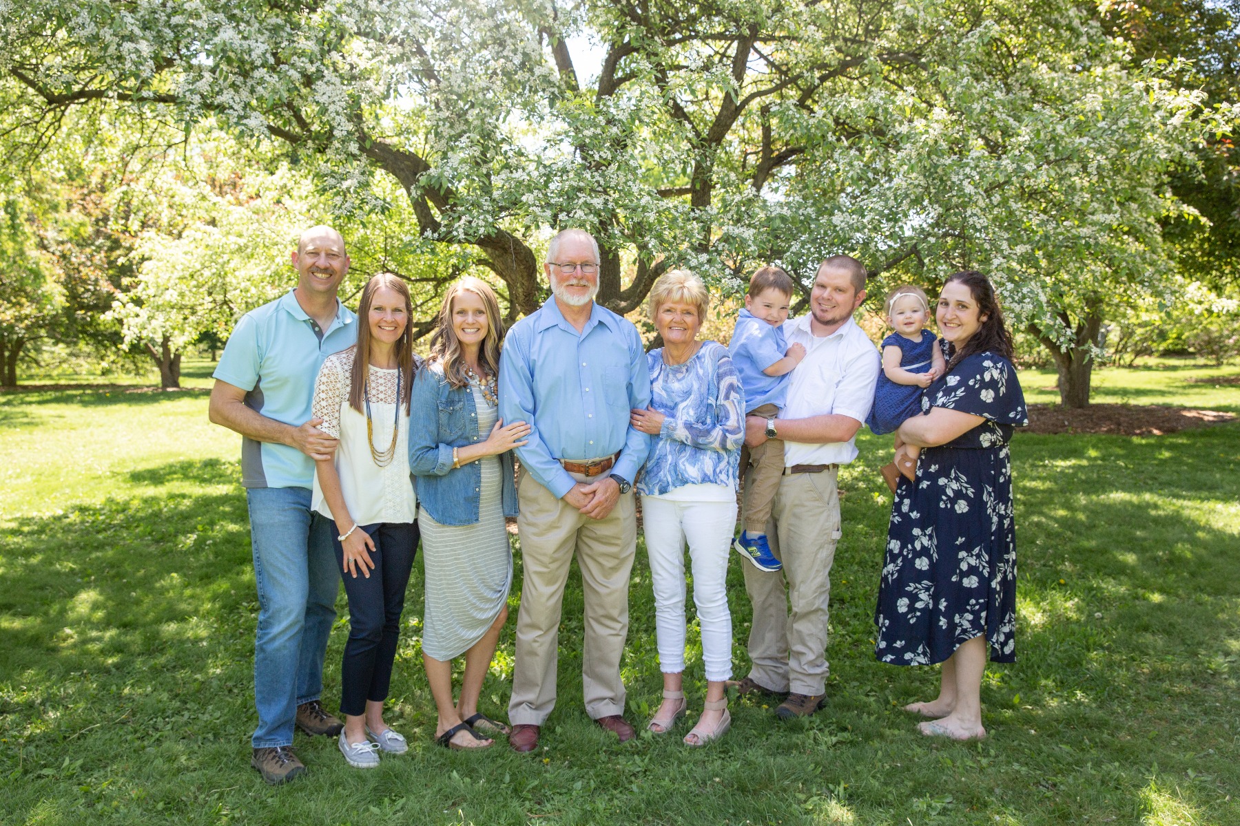 extended family of 9 in shades of blue & white under a white cherry tree