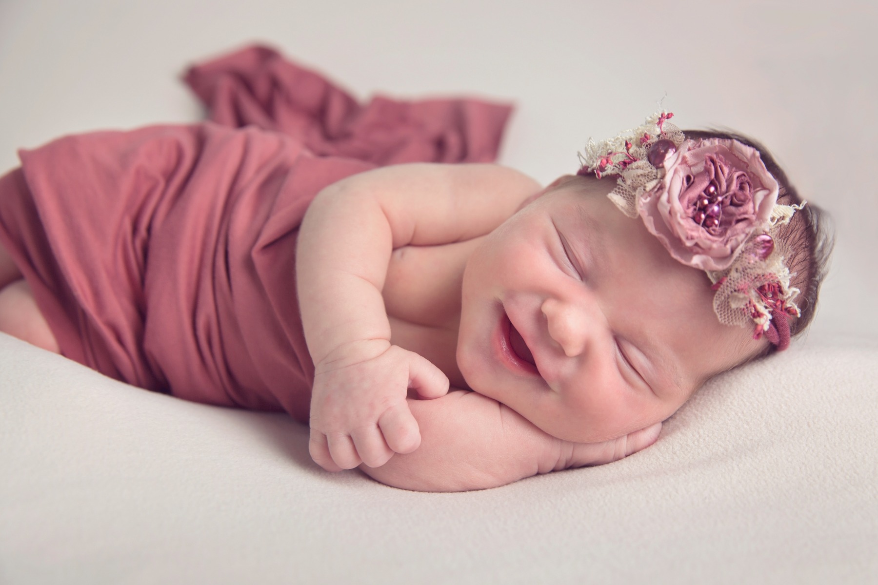 newborn baby smiles in her sleep