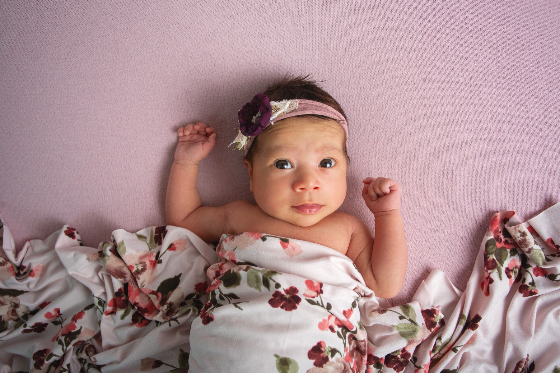 newborn baby in a floral swaddle