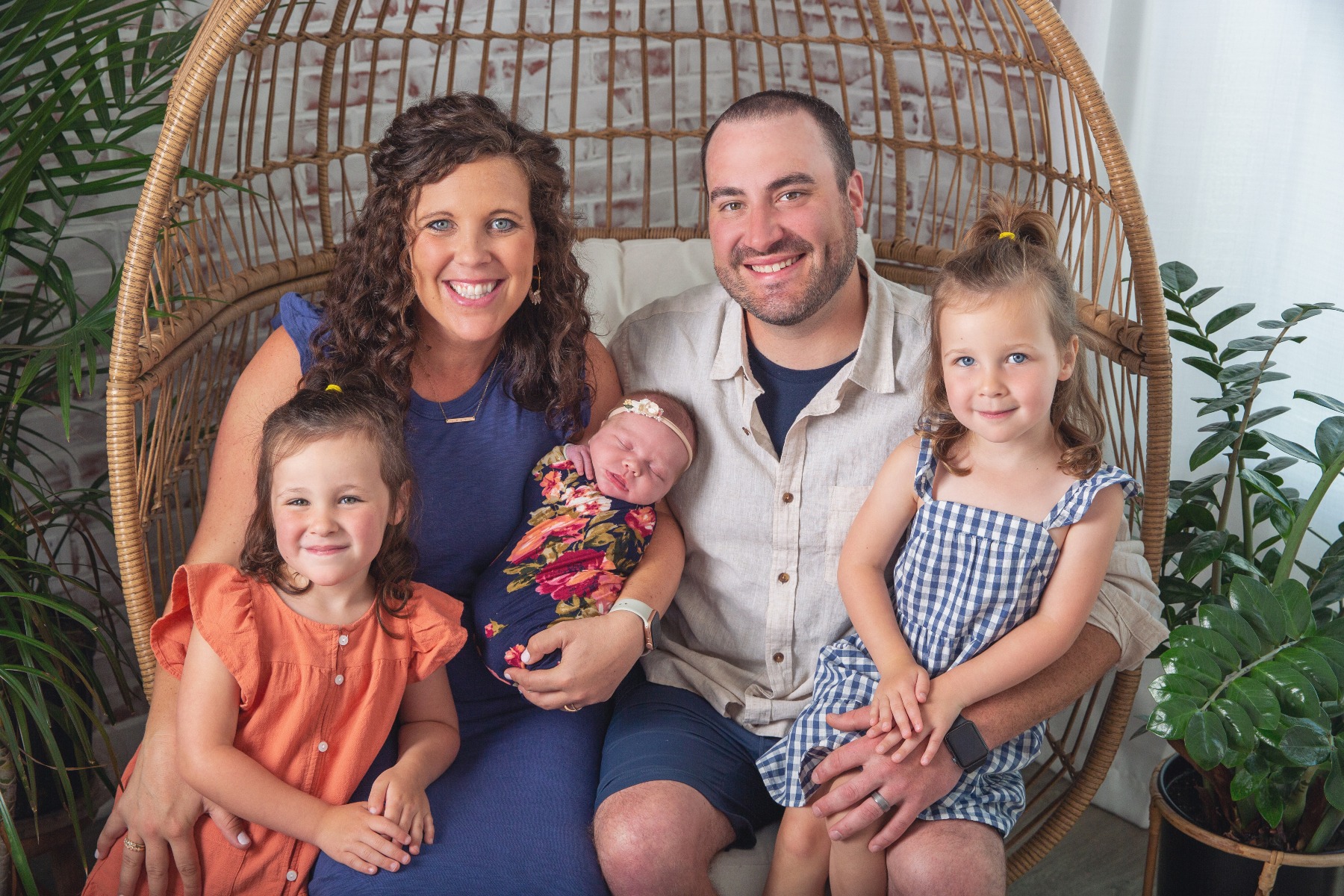 family of 5 poses with their newborn baby