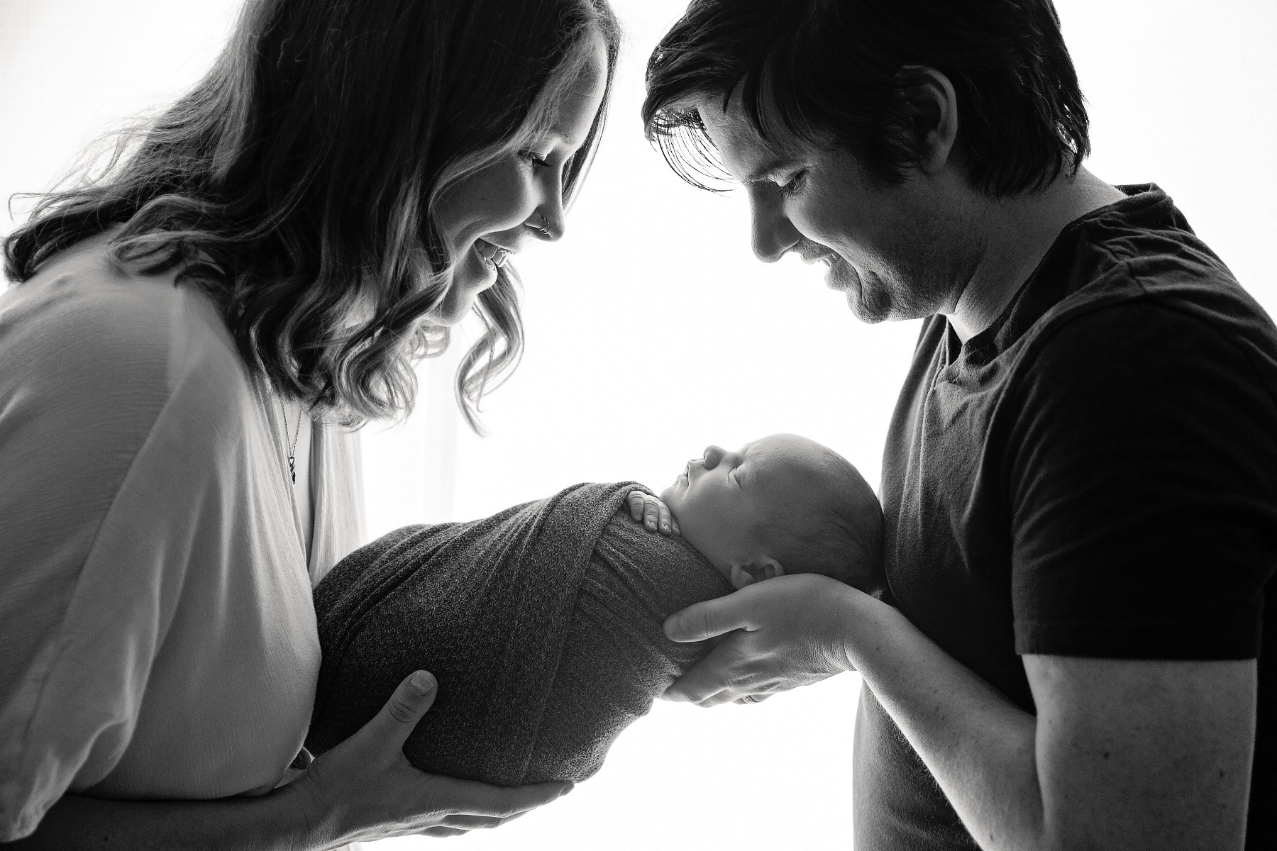 b&w silhouette of parents with their new baby