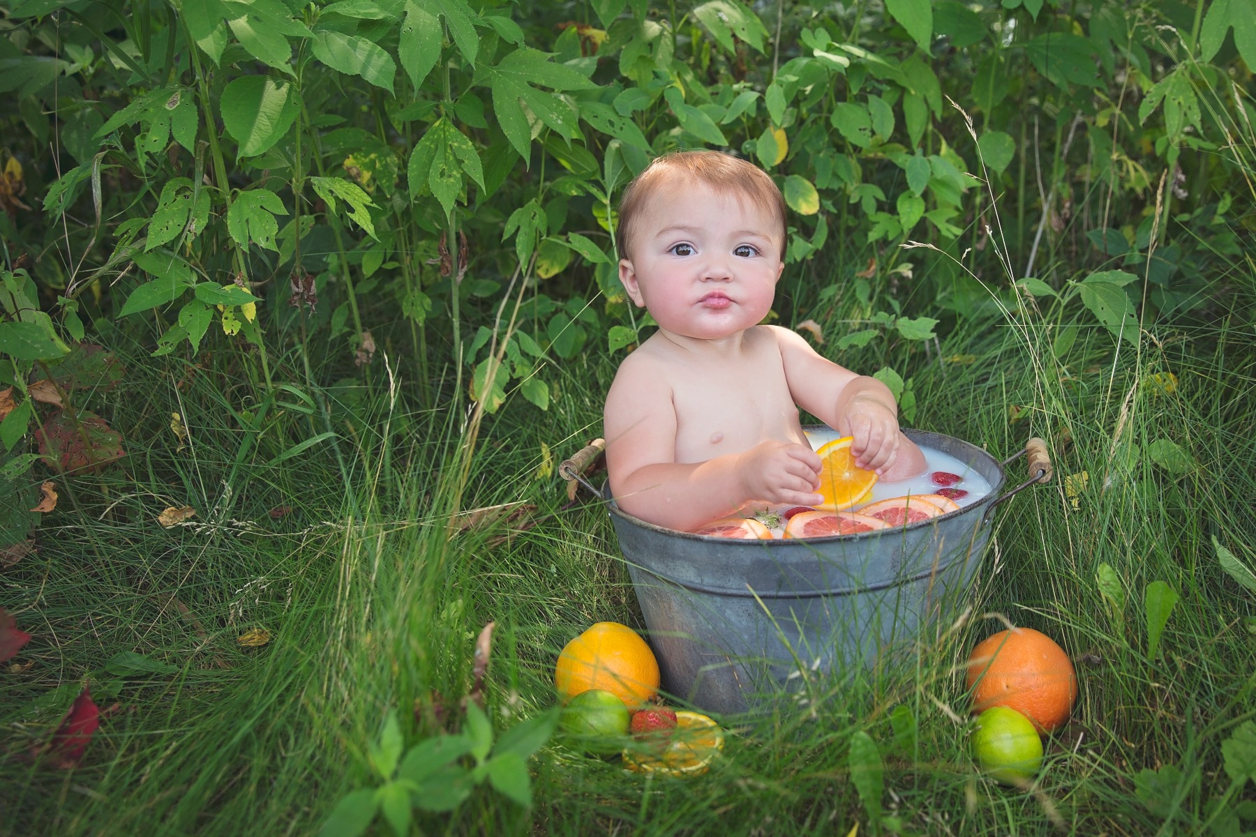 little girl plays in a fruit bath