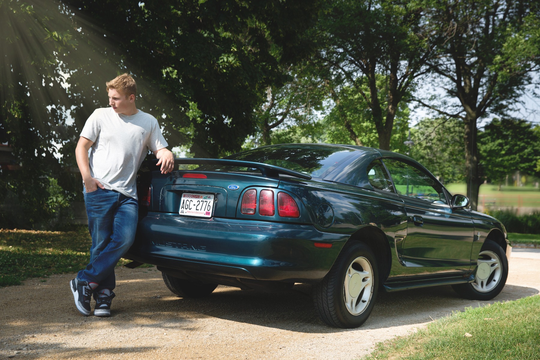 hs senior boy poses with his mustang