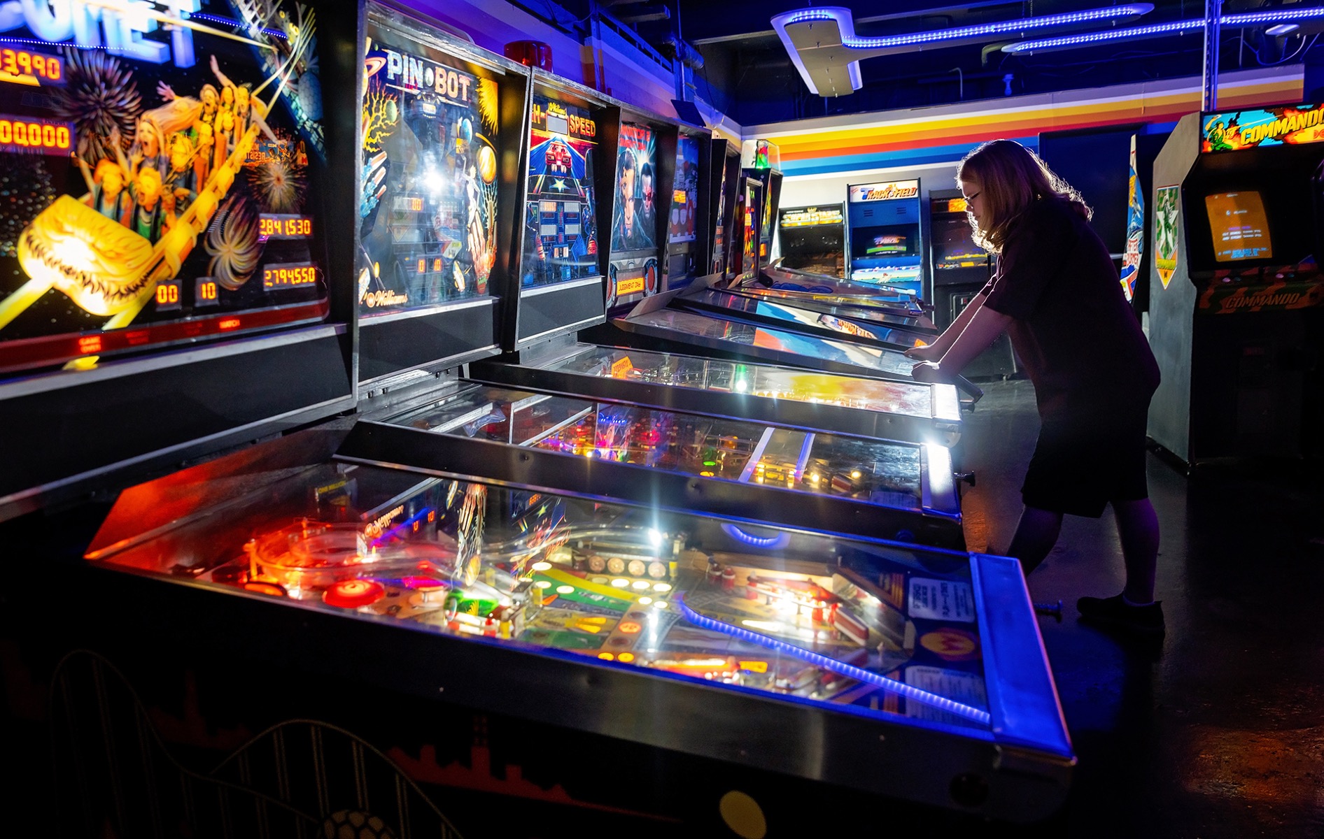 high school senior boy playing video games at an arcade